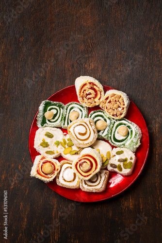 Assorted oriental sweets Turkish delight with nuts on a red plate