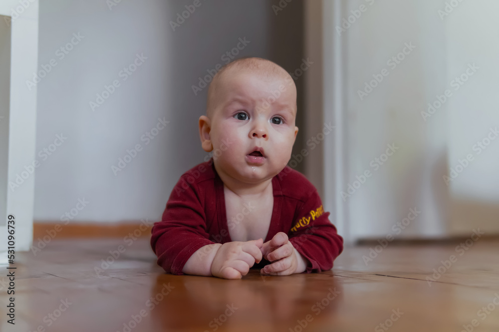 Cute baby crawling on the floor looking at parents Cute baby crawling on the floor looking at parents