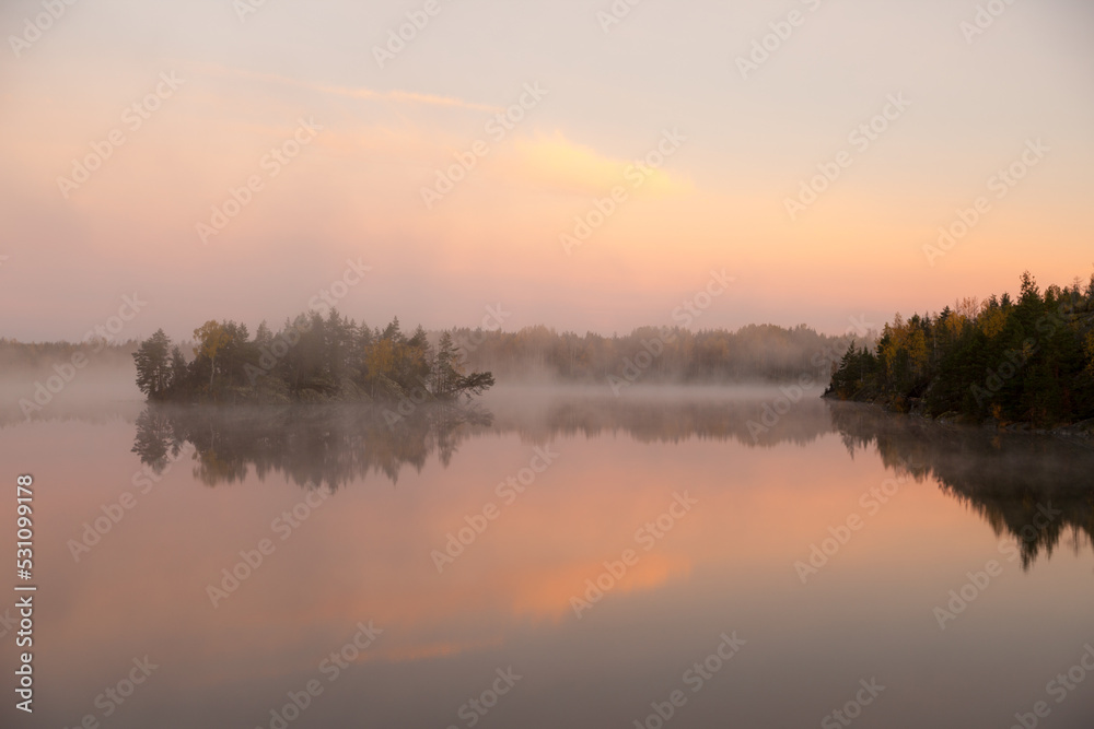 fog in the early morning on an autumn forest lake