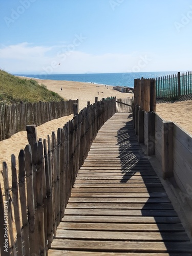 Wooden jetty on the beach on the Atlantic Ocean with sea and sun