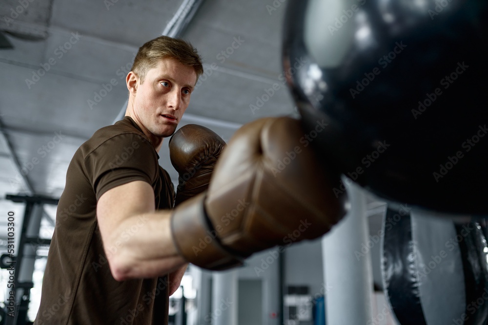 Close up boxer boxing in punching bag with focus on face
