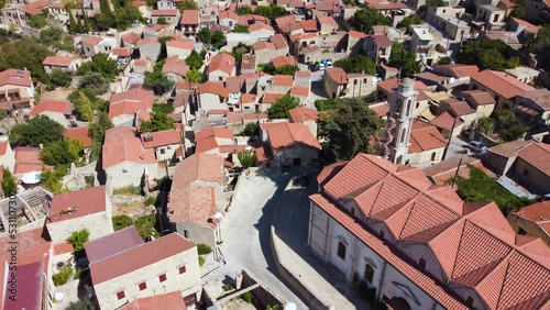 Aerial drone footage of traditional countryside village Lofou, in Limassol, Cyprus. Reveal scene of christian church Panayia Chrysolofitissa, ceramic tiled roof houses and narrow streets from above