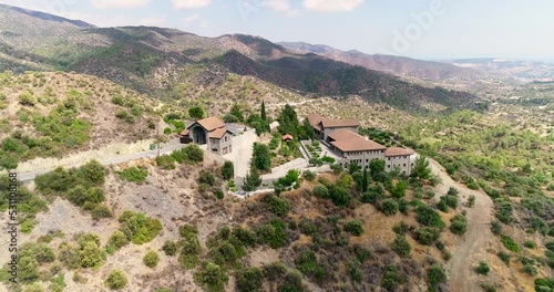 Aerial drone footage of Holy monastery of Panagia Amirous in Apsiou, Limassol, Cyprus. 360 view of the religious stone church, ceramic roof tiles and surrounding mountain landscape from above