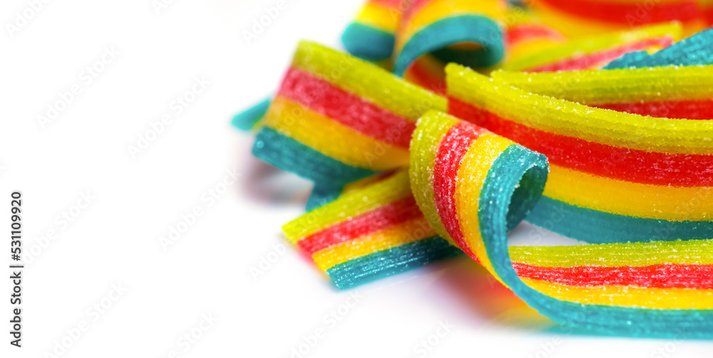 rainbow sour jelly candies strips in sugar sprinkle on white background
