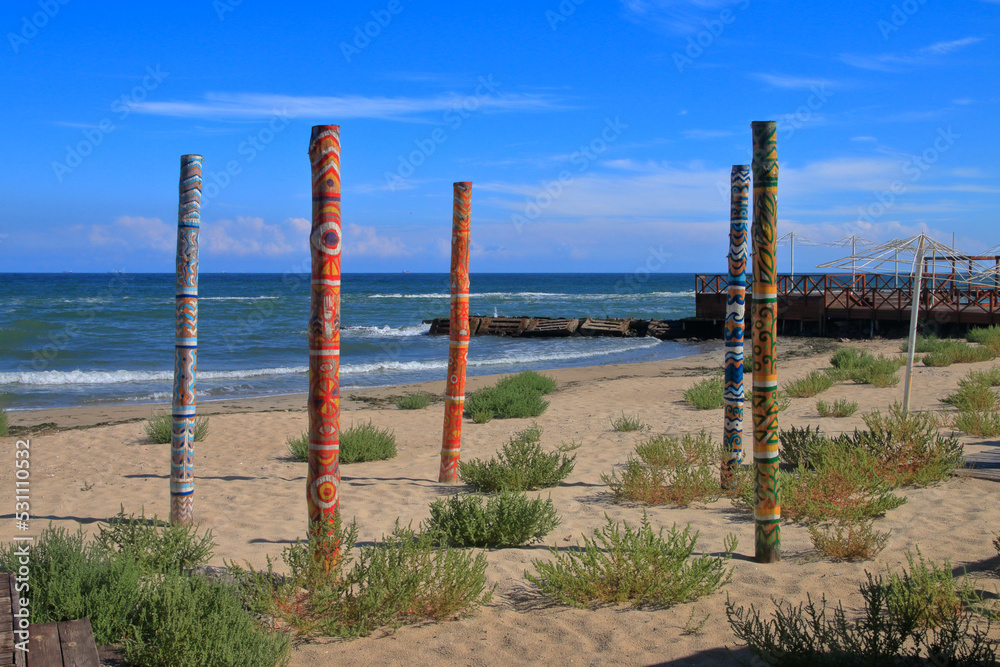 Seascape with brightly painted wooden poles.