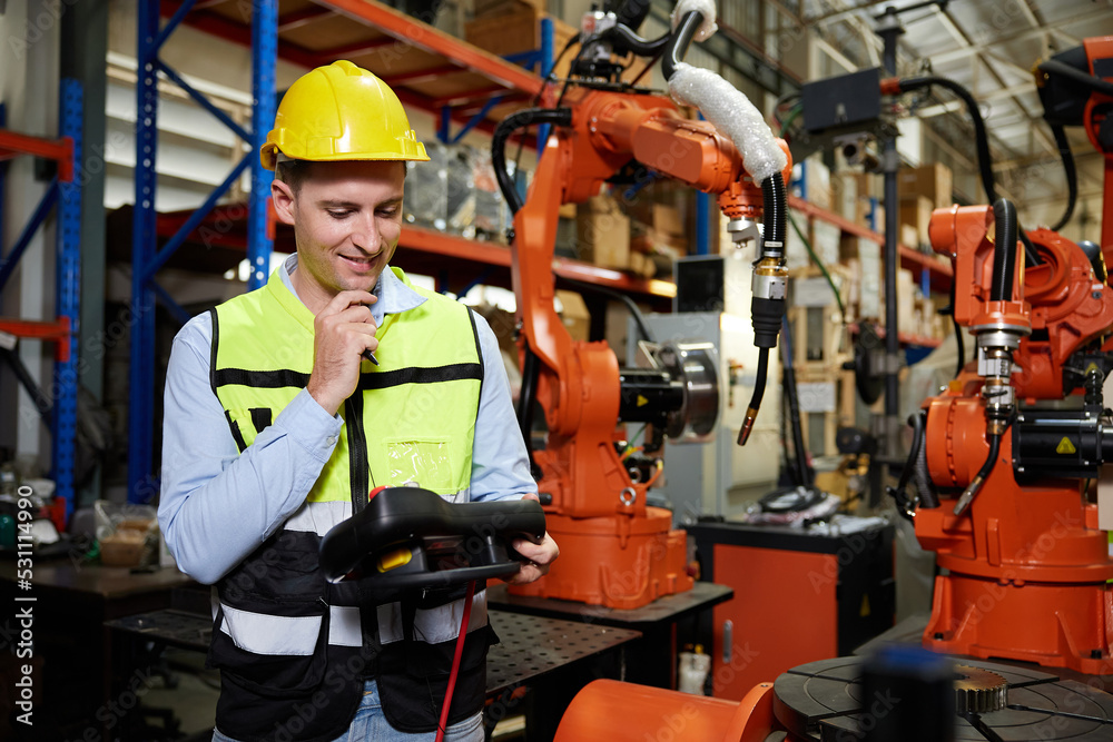factory worker or engineer operating remote switch controller to control robot machine in the factory factory worker or engineer operating remote switch controller to control robot machine in the factory