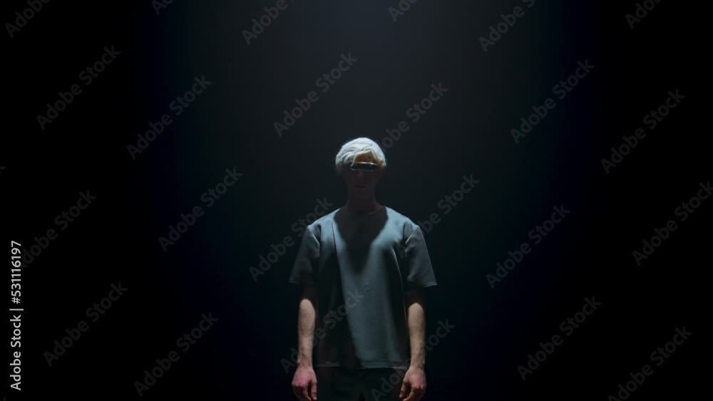 Man wearing virtual reality goggles in light. Unknown cyber player in dark room. Man wearing virtual reality goggles in light. Unknown cyber player in dark room.