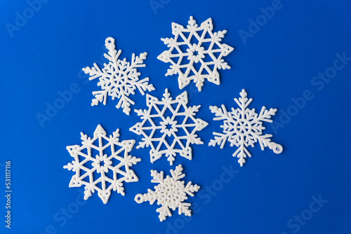 Christmas snowflakes on blue paper card. Vintage Christmas postcard with snowflakes. Beautiful christmas white stars on a blue background