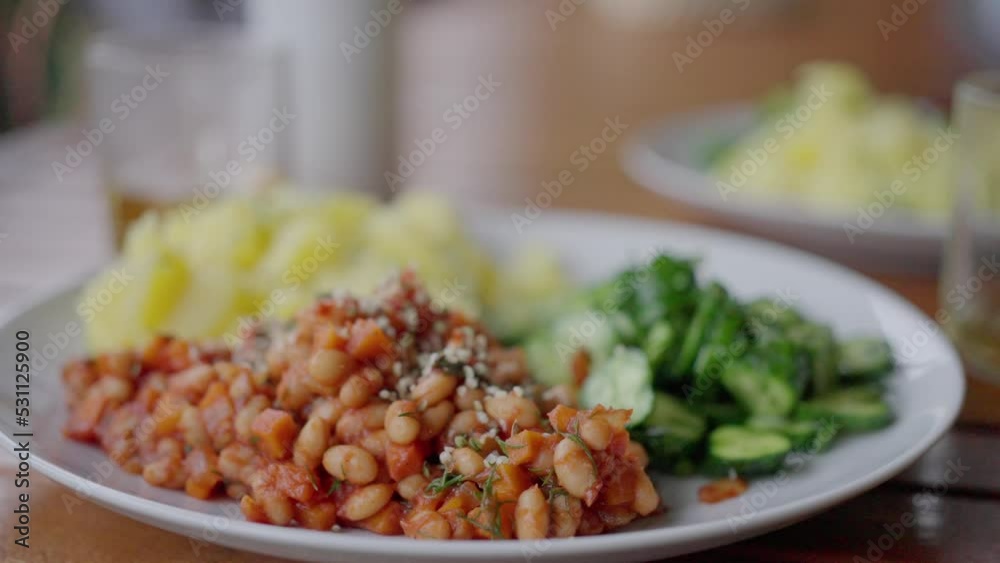 plate with beans, potatoes and salad, on the table. close-up. slow motion, vegan plate with beans, potatoes and salad, on the table. close-up. slow motion, vegan