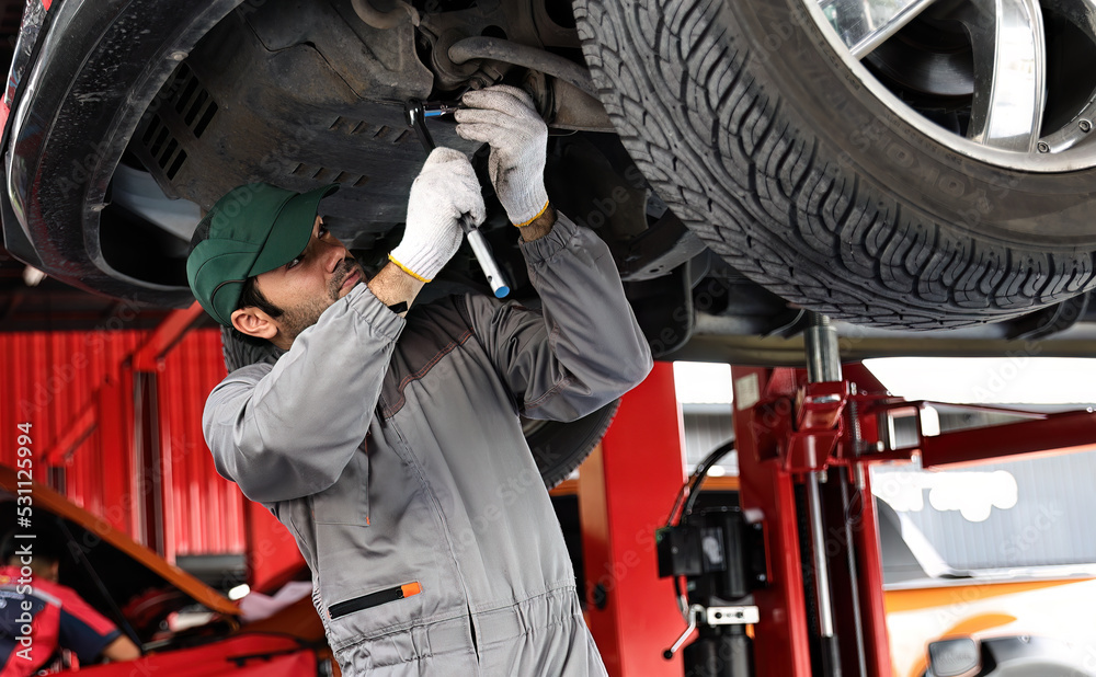 custom made wallpaper toronto digitalCar mechanic examining car suspension of lifted automobile at repair service station.