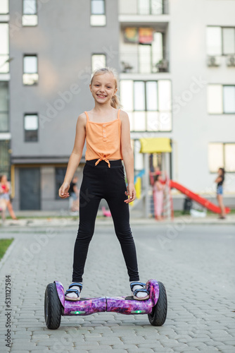 Child girl riding in on gyroscooter. Hobbies and active lifestyle in city.