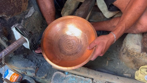 Man manually processing metal pots in the old Medina of Fes