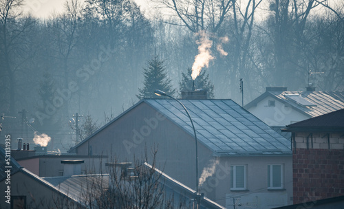 Lubaczow, Poland - March 15, 2022: Smoking chimneys during the heating season in winter in Poland. Air pollution and smog in winter. photo