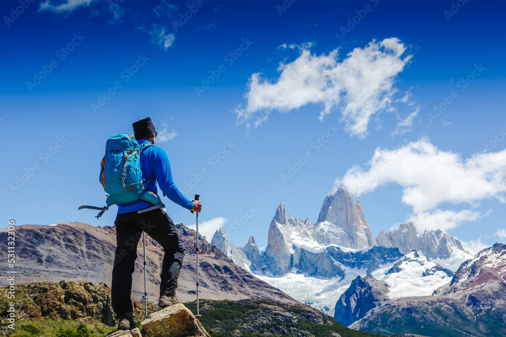 Hiker with backpack standing on top of a mountain and enjoying the view. Happiness Discovery Travel Destination Concept