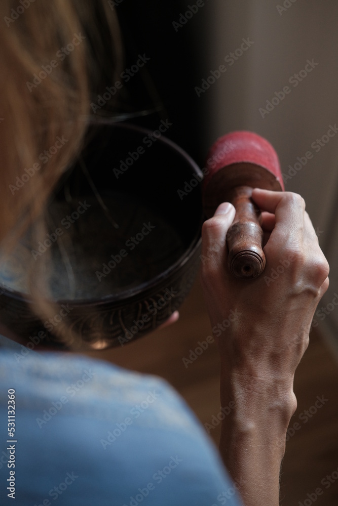 Women in a blue scarf using singing copper bowl. Yoga, relaxation and meditation. Sound therapy, alternative medicine Women in a blue scarf using singing copper bowl. Yoga, relaxation and meditation. Sound therapy, alternative medicine