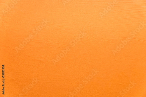 Abstract orange plaster wall texture. Yellow or orange painted plaster cement wall vintage style. Orange color stucco wall with copy space. Bright art wallpaper