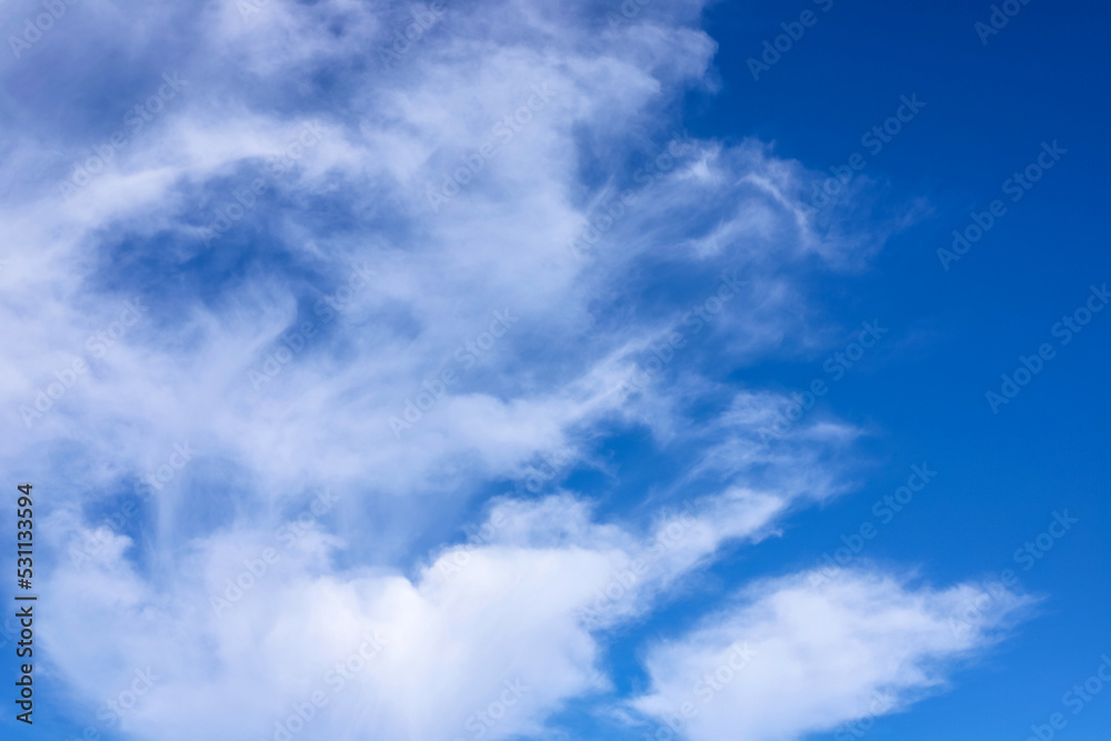 Blue sky with fluffy clouds as a tranquil background