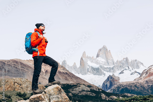 Hiker with backpack standing on top of a mountain and enjoying the view. Happiness Discovery Travel Destination Concept © olyphotostories