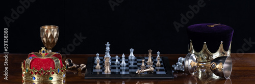 medieval king playing chess, black studio background