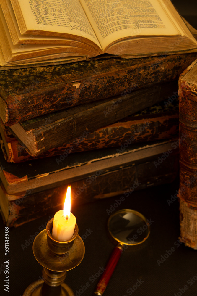 old books on the table, reading by candlelight, magnifier old books on the table, reading by candlelight, magnifier