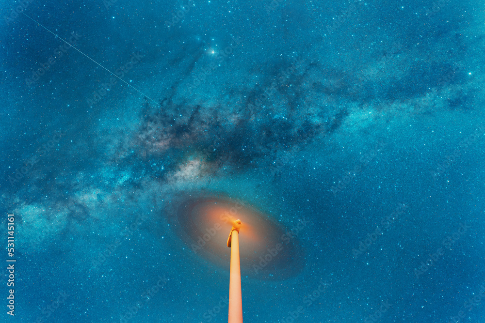 Fototapeta premium night sky over a spinning wind turbine, long exposure.