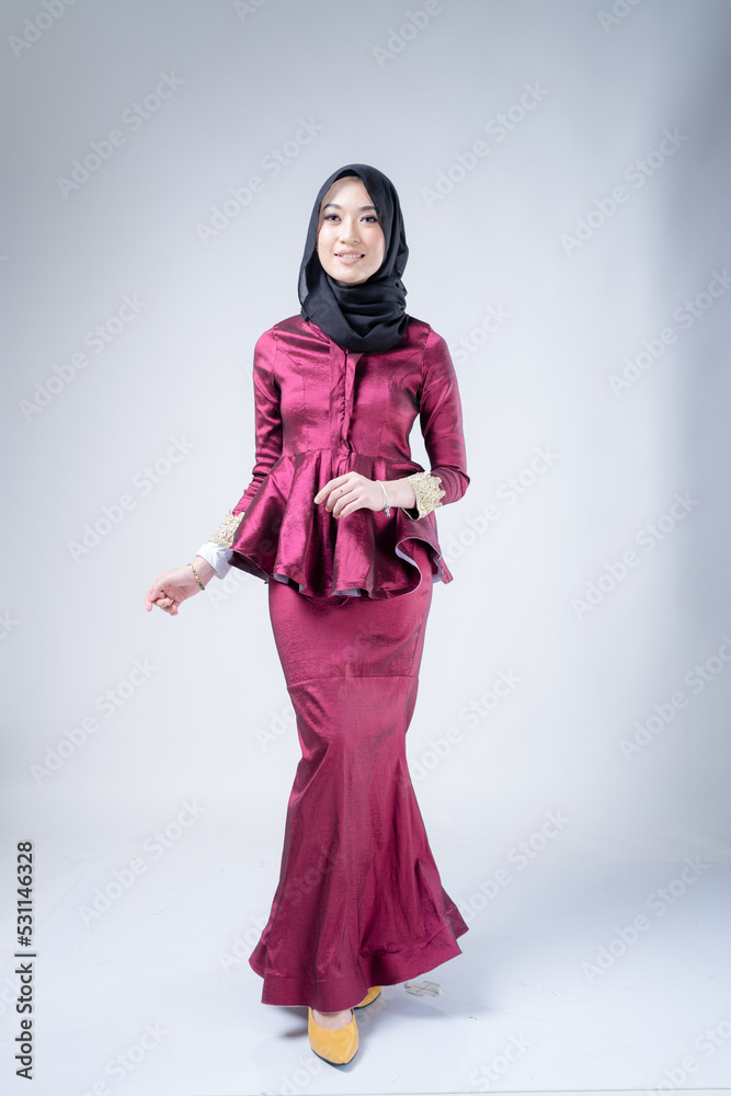 Portrait of a beautiful female Muslim model wearing hijab, a lifestyle apparel for Muslim women isolated on white background. Modern hijab fashion concept.