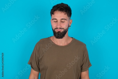 young bearded hispanic man wearing casual clothes over blue background nice-looking sweet charming cute attractive lovely winsome sweet peaceful closed eyes