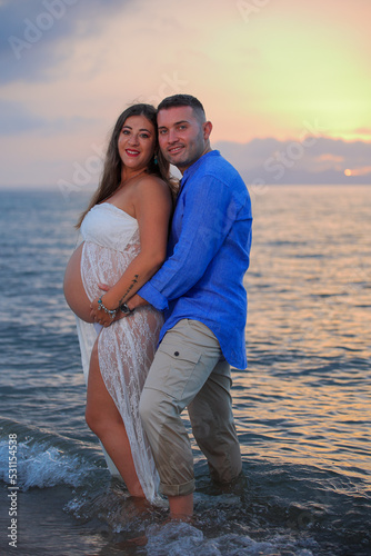 Sposi in riva al mare, lui abbraccia lei al nono mese di gravidanza
