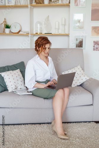 A business woman with a laptop. A human design specialist works at home on a laptop. Work from home during the epidemic photo