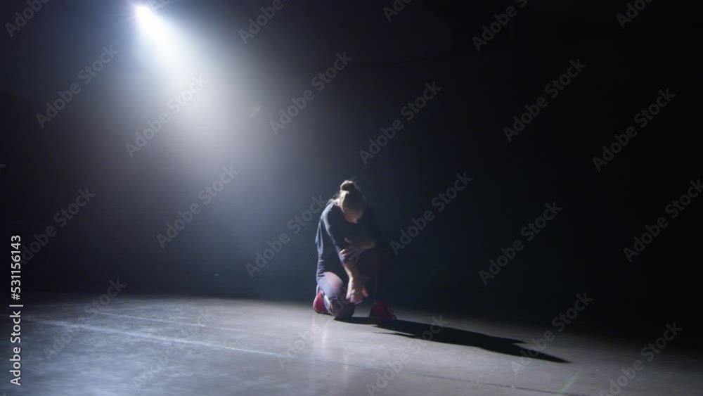 The light of the projector in the darkness turns on a dance doing a choreography
