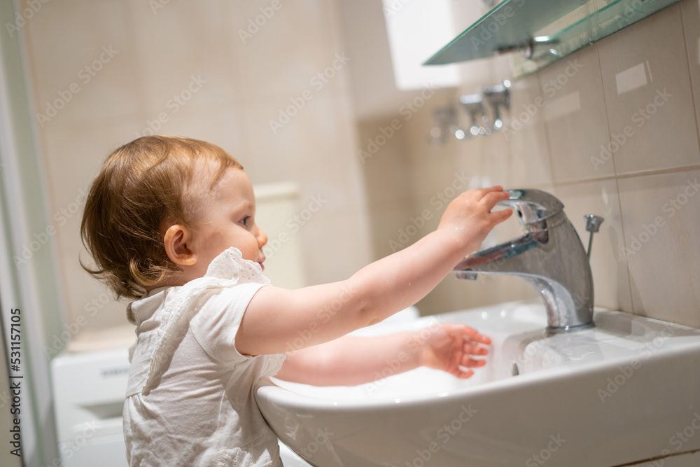 Cute toddler in the bathroom mirror learning how to wash his face Cute toddler in the bathroom mirror learning how to wash his face