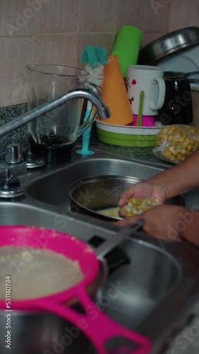 woman squeezing nance in a pan, close-up photo