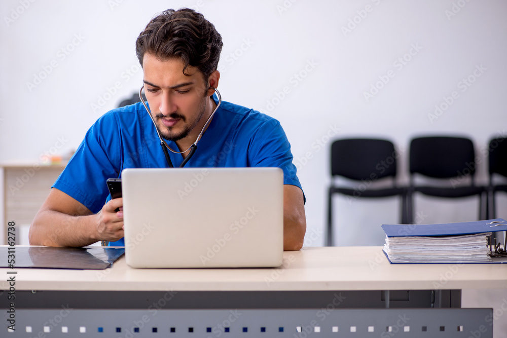 Young male doctor working in the clinic Young male doctor working in the clinic