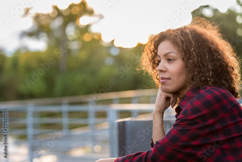 Woman in her thirties thinking as the sun sets. High quality photo