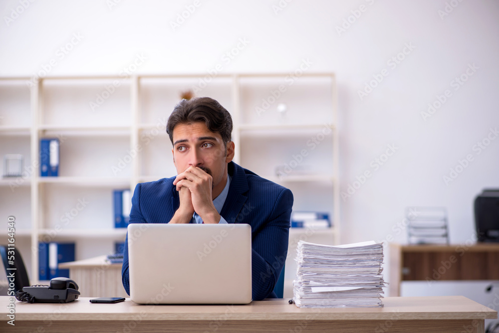 Young businessman employee and too much work in the office Young businessman employee and too much work in the office