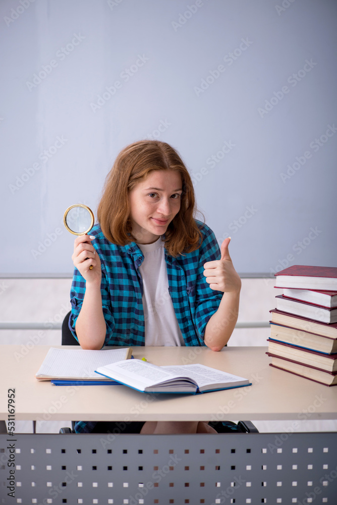 Young female student preparing for exams in the classroom Young female student preparing for exams in the classroom