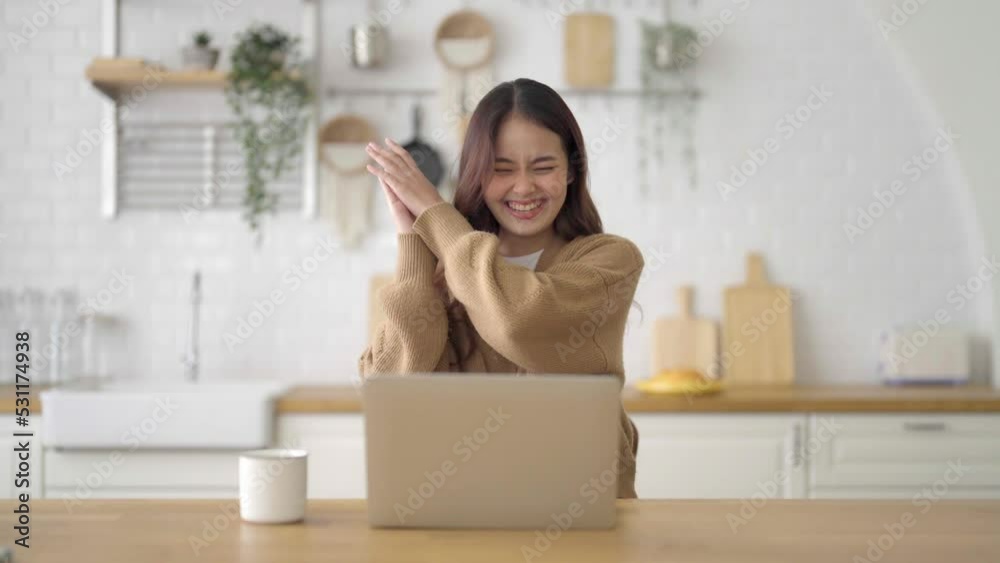Smiling asian young woman working on laptop at home office. Young asian student using computer remote studying, virtual training, e-learning, watching online education webinar at house Smiling asian young woman working on laptop at home office. Young asian student using computer remote studying, virtual training, e-learning, watching online education webinar at house