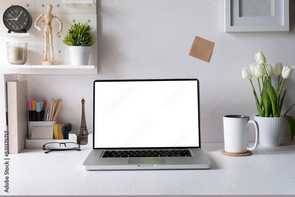 Front view of laptop compute with empty display, coffee cup and stationery on white table. Front view of laptop compute with empty display, coffee cup and stationery on white table.