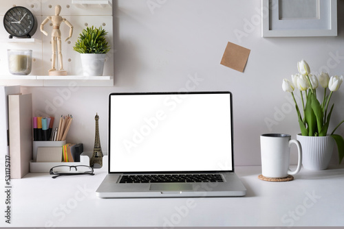 Front view of laptop compute with empty display, coffee cup and stationery on white table. © wattana