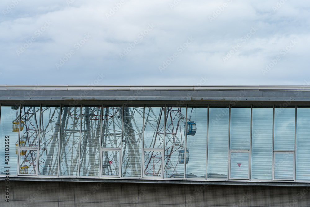 Obraz premium ビルの窓ガラスに反射する観覧車