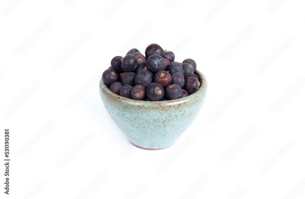 Whole Juniper Berries in Green Pottery Bowl in Side View Shot Isolated on White Whole Juniper Berries in Green Pottery Bowl in Side View Shot Isolated on White