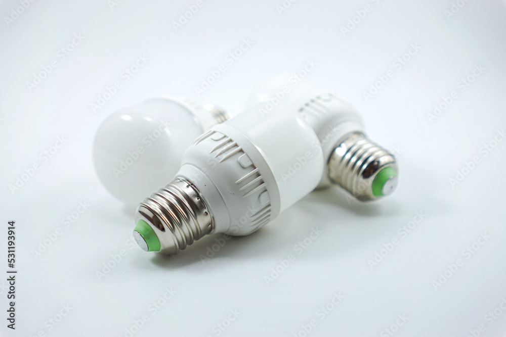 concept of three small white energy-saving light bulbs isolated on a white concept of three small white energy-saving light bulbs isolated on a white