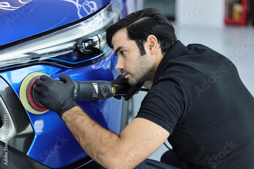 Wallpaper Mural Master polishes the deep blue car via polish mashine in a car workshop. Torontodigital.ca
