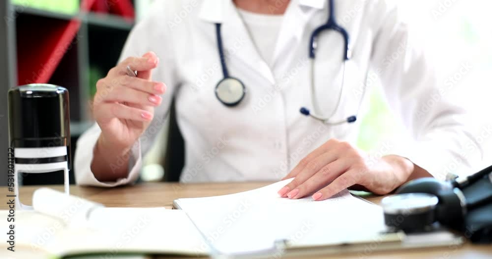 Doctor puts stamp on medical documents closeup Doctor puts stamp on medical documents closeup