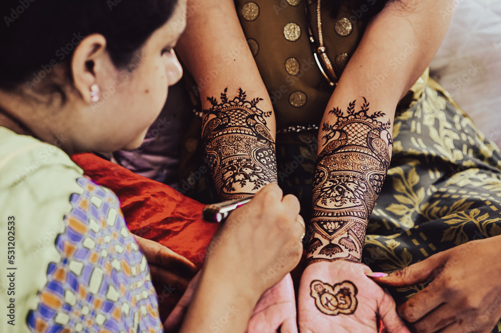 Master Applying henna tattoo on a bride hands. Elegant Brown Colors of Henna  Ink. Indian Traitional Mehendi Ceremony. Stock Photo | Adobe Stock