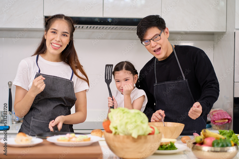 Father , Mother and Daughter spend time for happy activity together in home kitchen Father , Mother and Daughter spend time for happy activity together in home kitchen