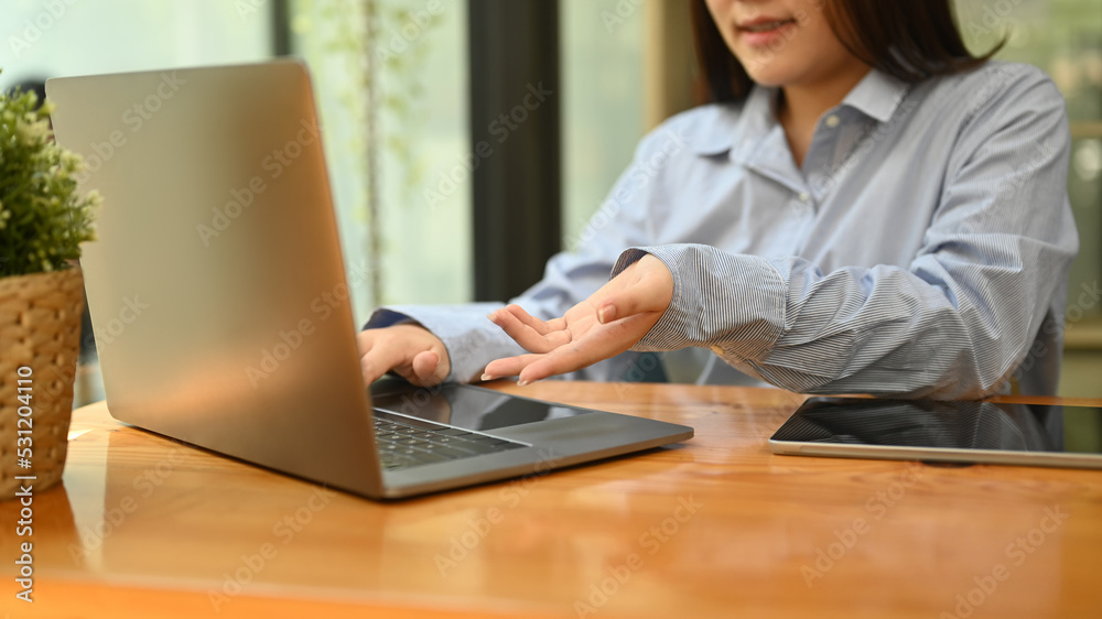 Cropped shot of female employee working, analyzing information on her laptop computer Cropped shot of female employee working, analyzing information on her laptop computer