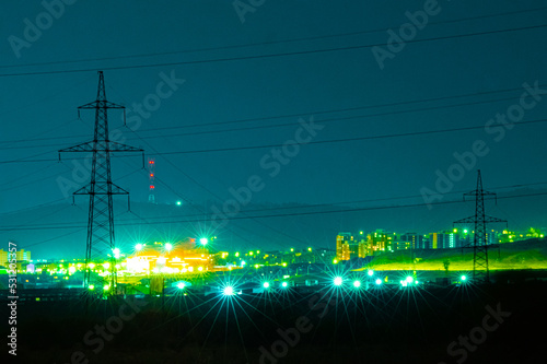 power lines at night against the city lights