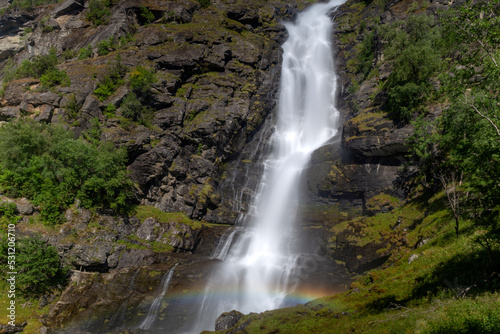 waterfall with rainbow in the green mountains 