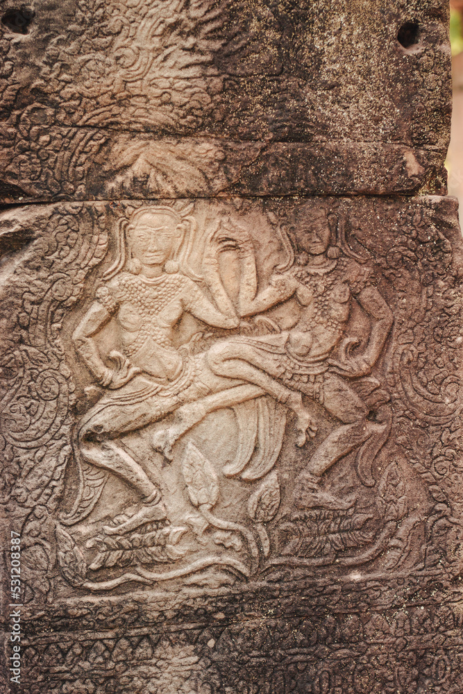 Siem Reap, Cambodi - March 19th, 2020 : buddhists figures carved in the stone walls of a temple at Angkor Wat archeological complex